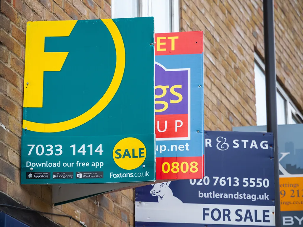 Estate agents' for-sale boards on a London house